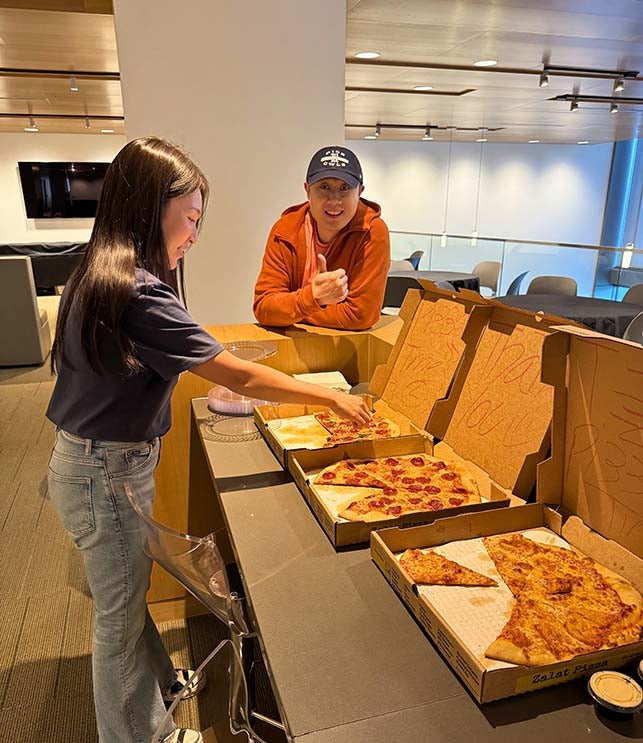 chinese man and japanese woman eating pizza inside university building