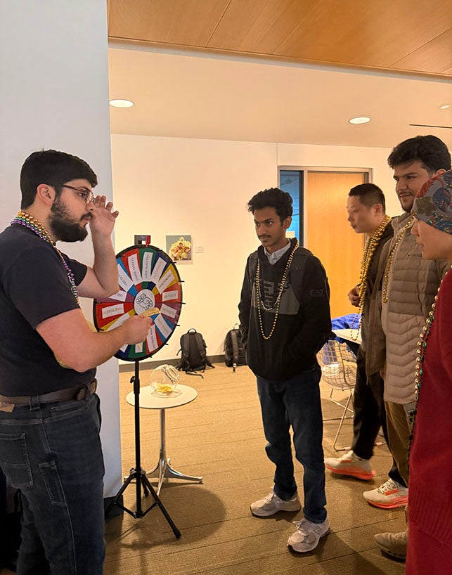 adult students standing next to a prize wheel
