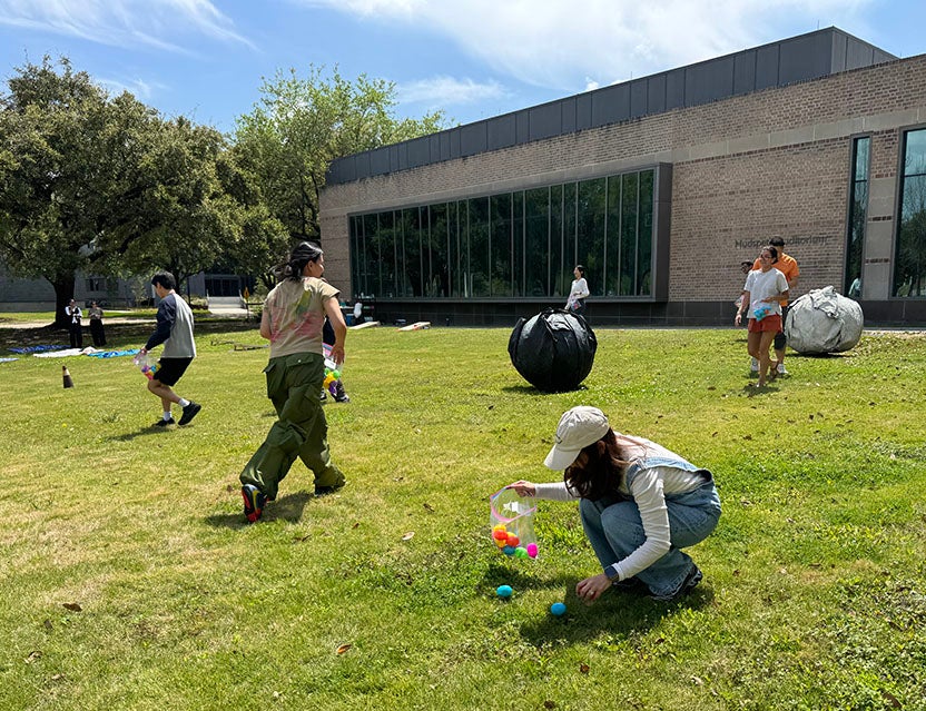college students having an easter egg hunt outside