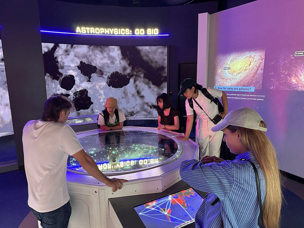 adults looking at at astrophysics exhibit