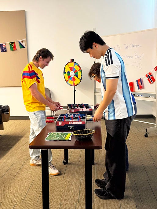 two college aged boys playing foosball