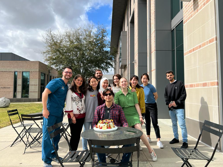 group of college students celebrating a birthday outside