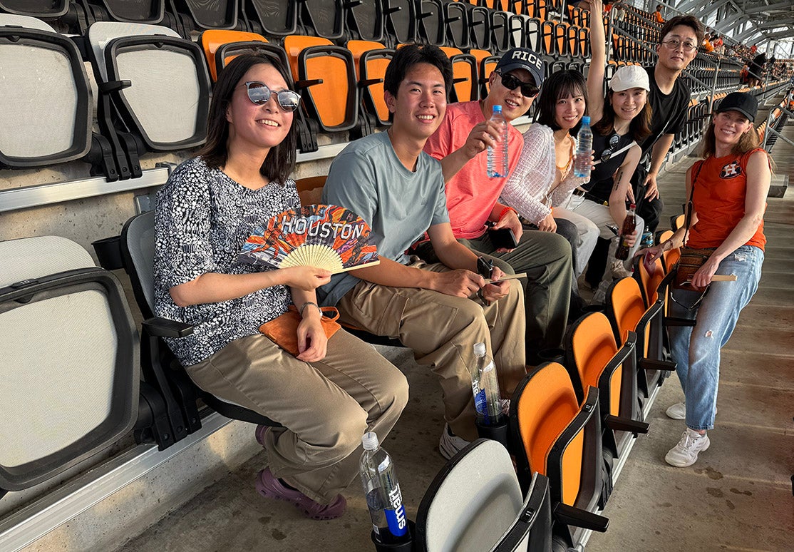 group of adult students watching a soccer match in a large stadium