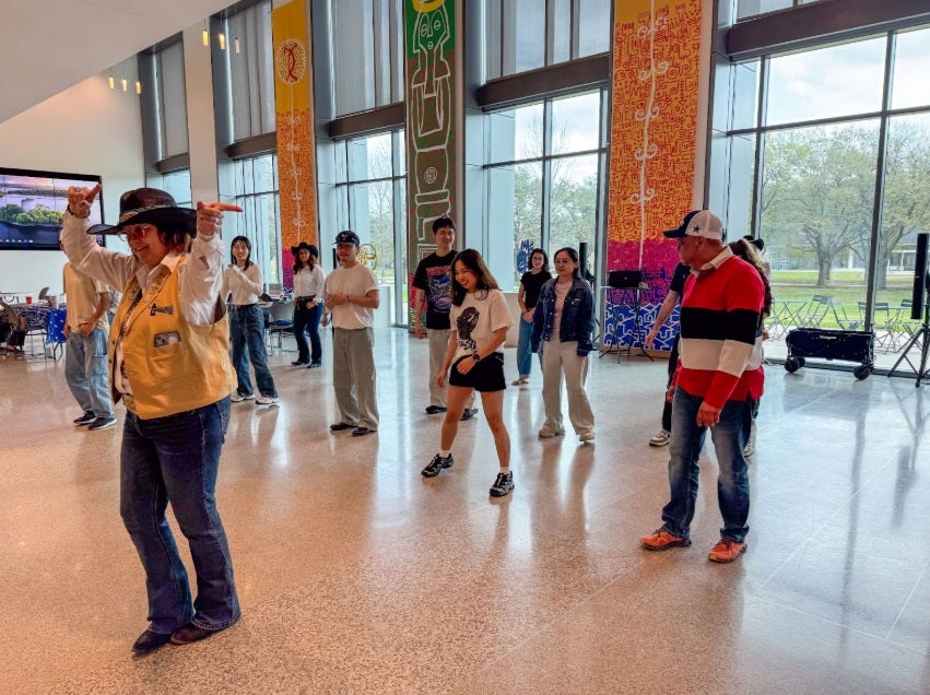 diverse group of adult students line-dancing inside