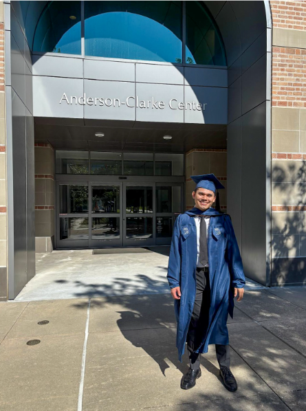 male college student wearing his gap and gown
