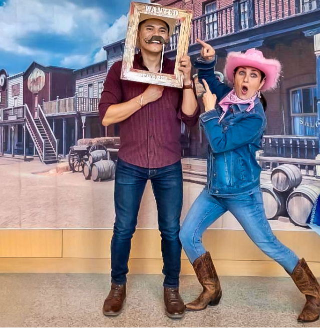 a man and woman wearing western clothing and posing in a silly way