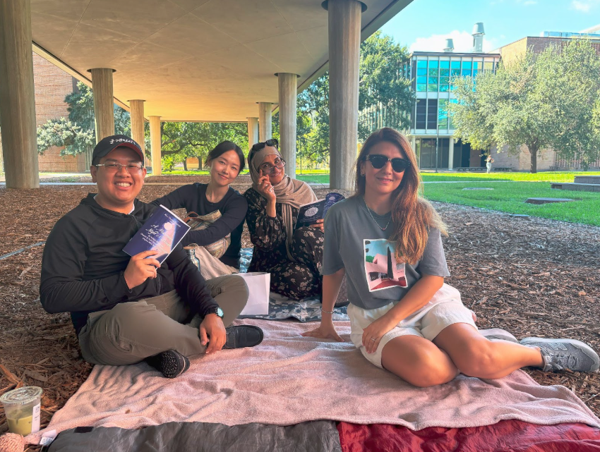 3 women and 1 man sitting outside at a park