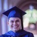 a male college student wearing his cap and gown